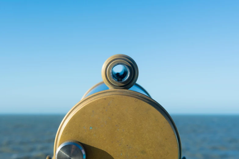 closeup of an antique looking telescope on the beach