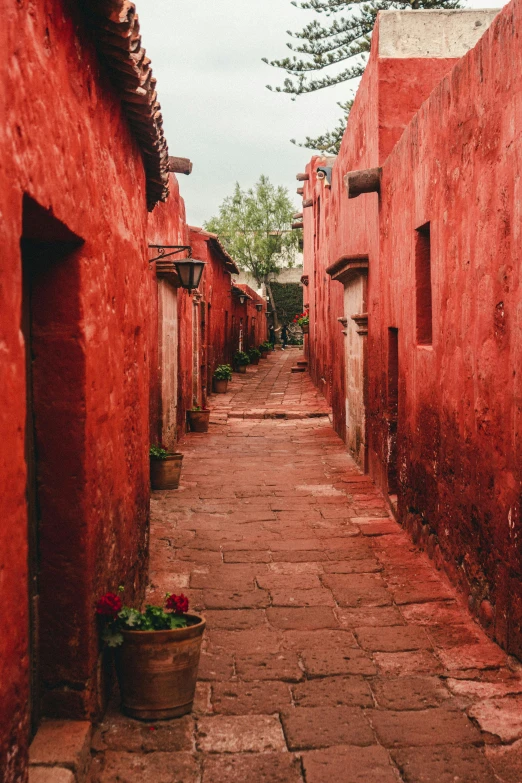 an empty alley with red walls and cement flooring