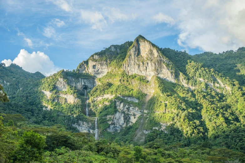 this is the side of a large mountain that has a waterfall