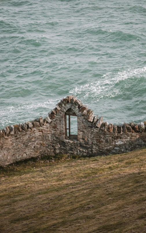 the stone wall is next to the water