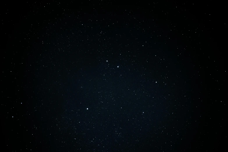 a dark night sky with white stars above it