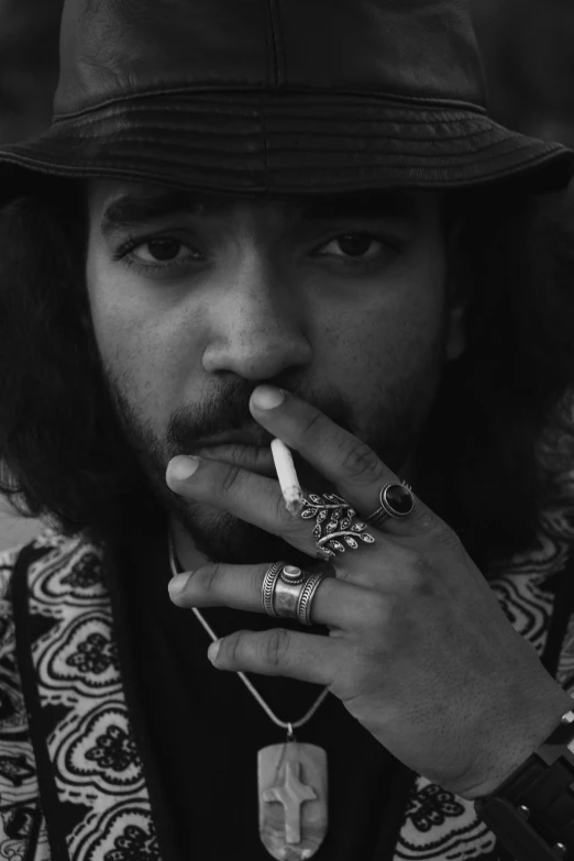 a man with a hat smoking a cigarette