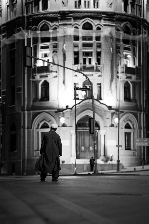 a man is standing in front of an old building at night