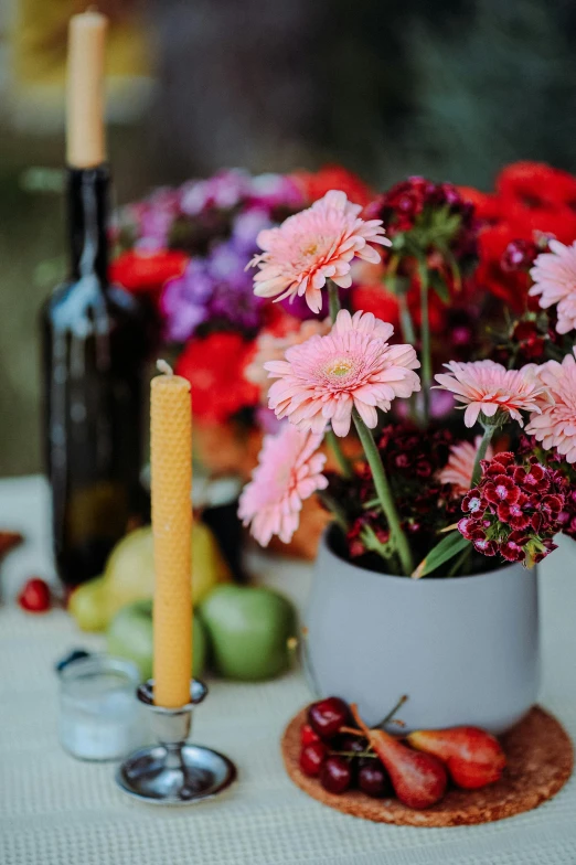 a bunch of flowers on a table next to a candle