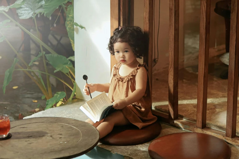 a little girl is sitting down reading a book