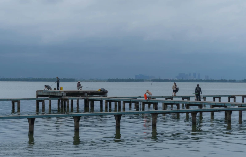 many people walk along the pier on a cloudy day