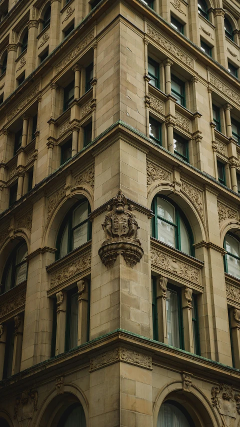 an old building has green windows and a clock on the side