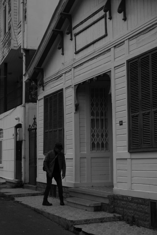 two men walking down a street near tall white buildings