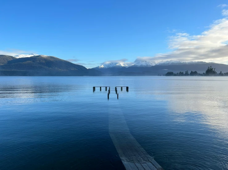 a large body of water sitting below a mountain range