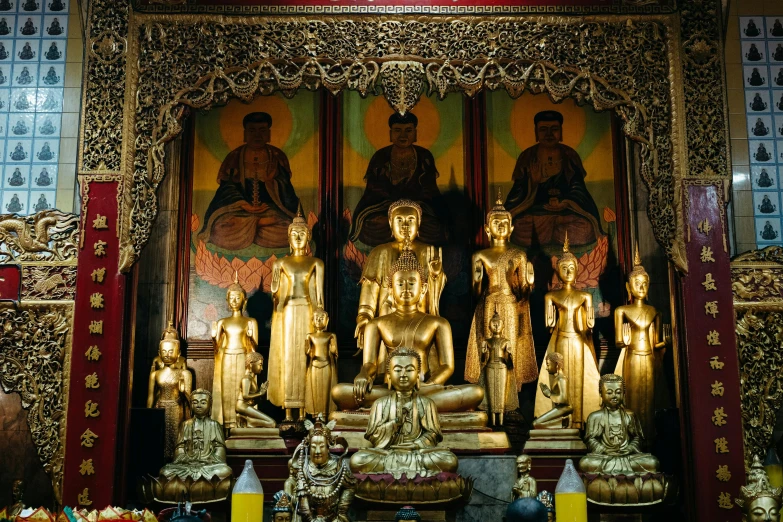 some statues are gold and there is a yellow light