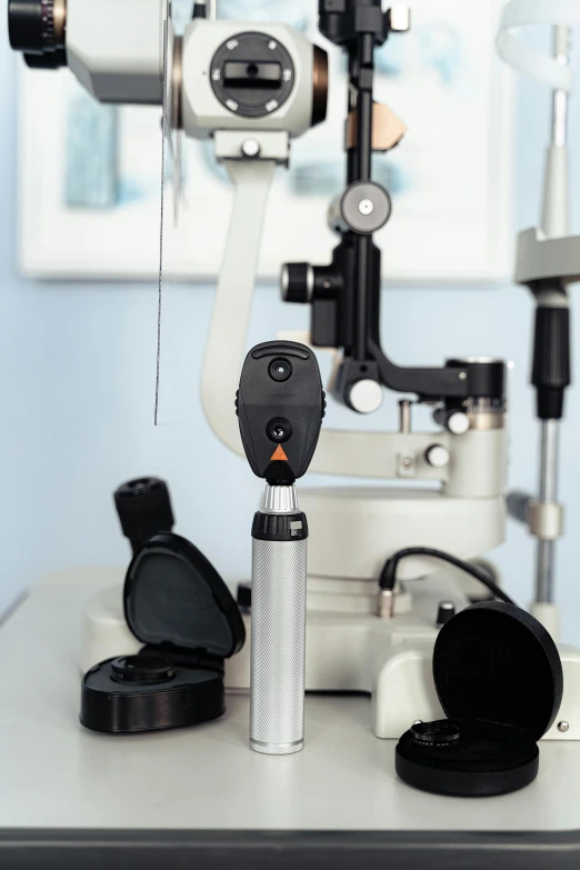 a camera, some sort of eye glasses, and some microscopes on a table