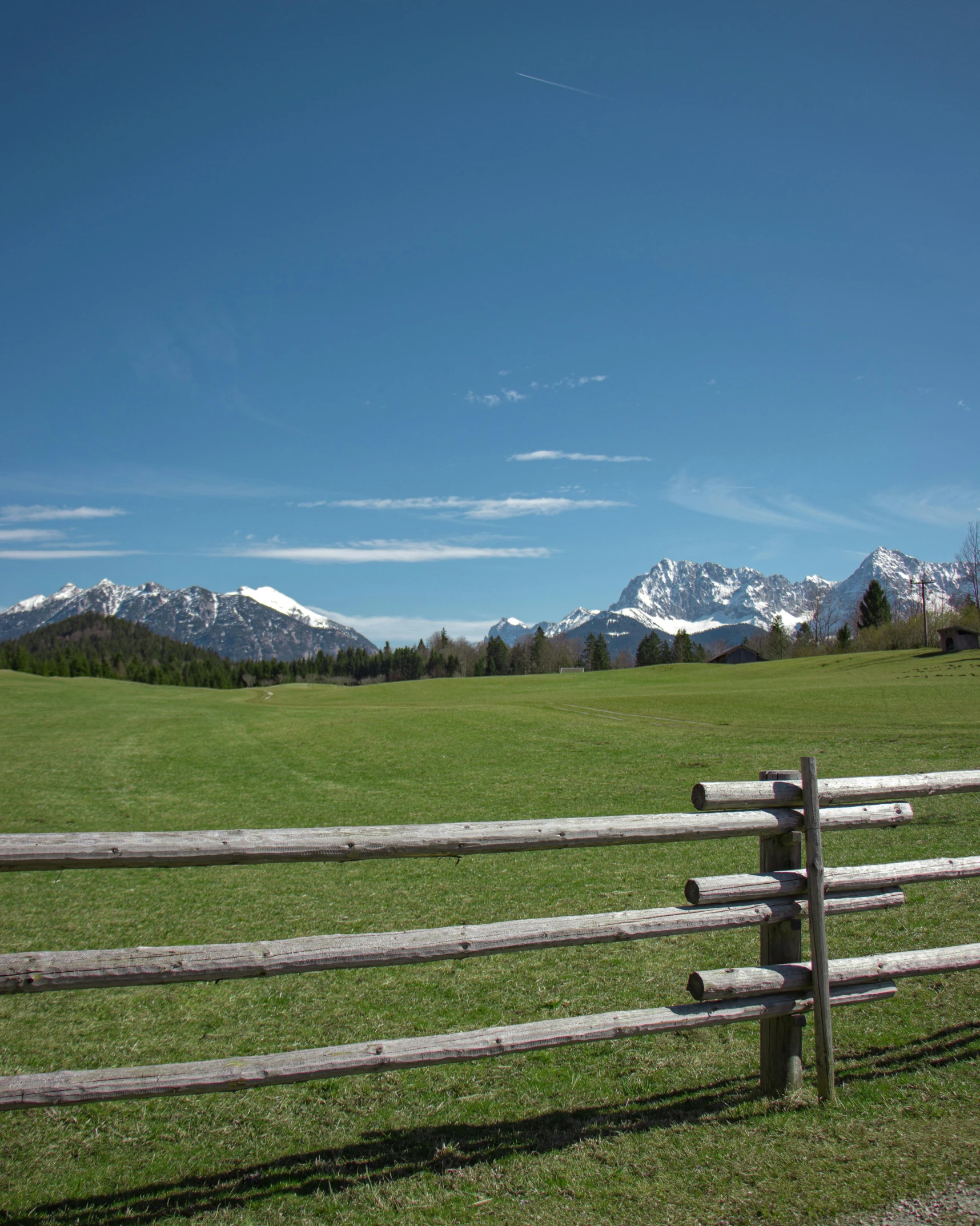 a wooden fence sitting in the middle of a lush green field