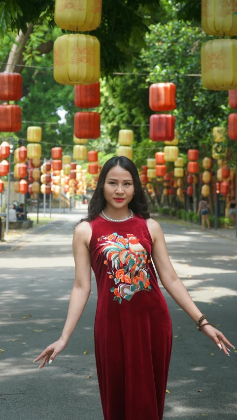 a woman is standing on a path near lanterns