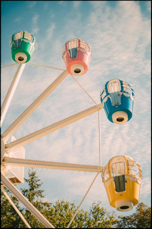 three brightly colored carnival ferris wheels against a blue sky