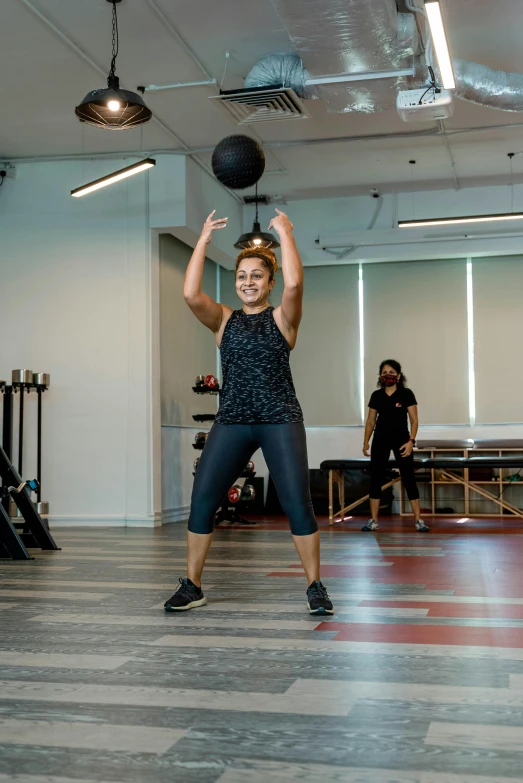 woman in grey top throwing up a basketball