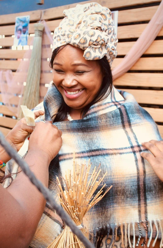 the lady smiles as she puts on her hat