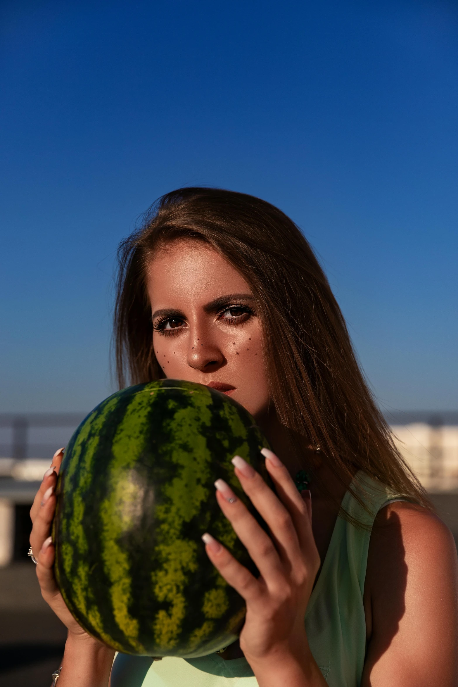 a beautiful young woman holding a large watermelon