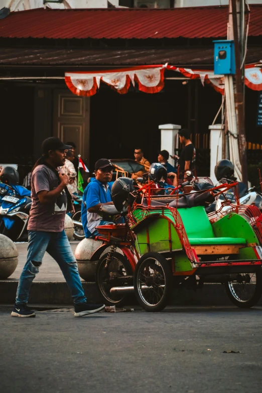 two men are walking past a cart filled with motorcycles