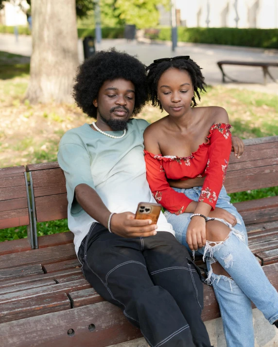 couple sitting on park bench smiling at each other