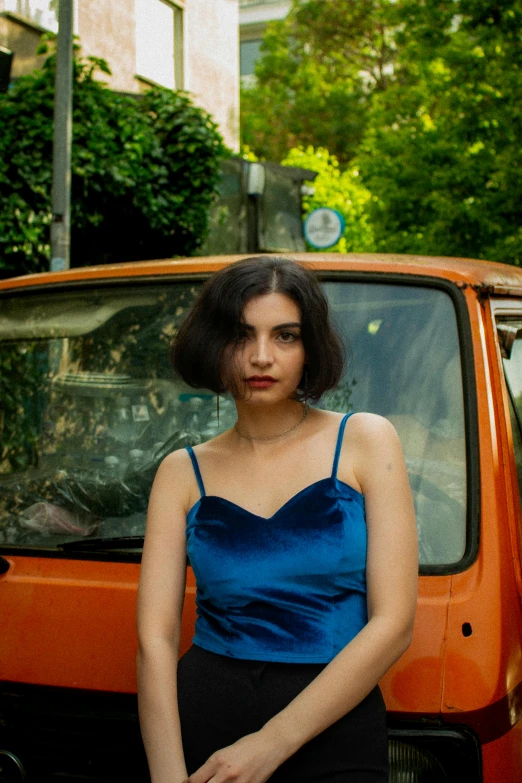 a woman standing next to a parked orange truck