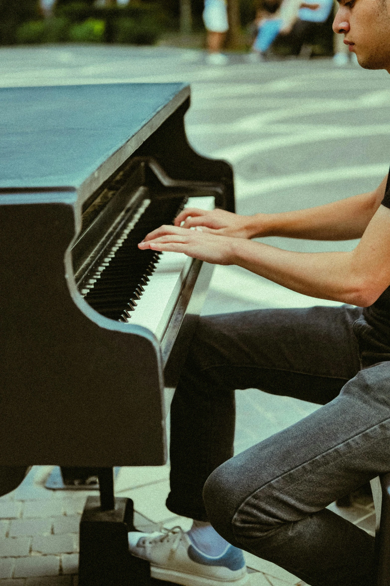 man with jeans and shoes sitting at a piano