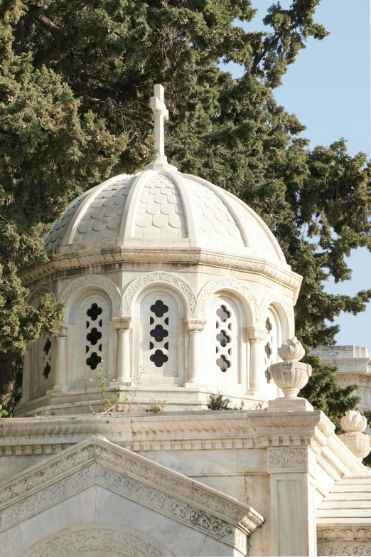 an elegant white and stone building with a domed top