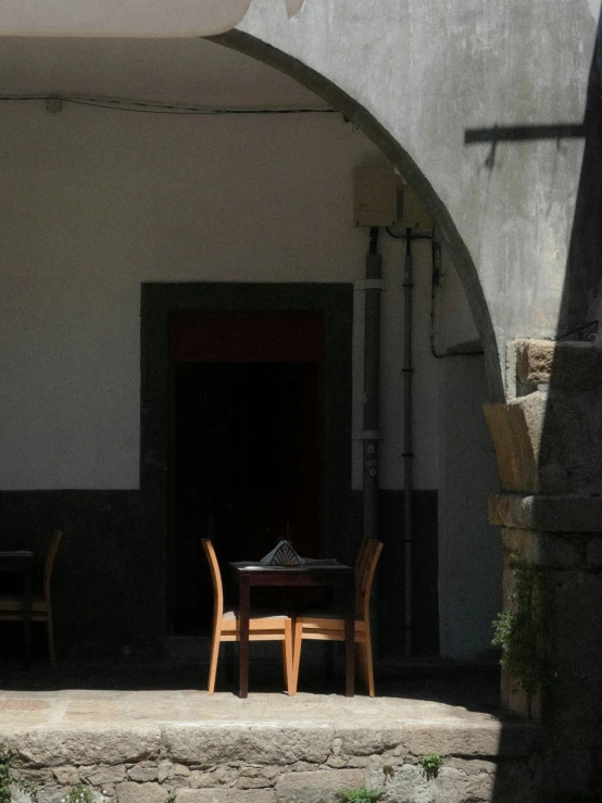 some chairs and a table in a stone courtyard