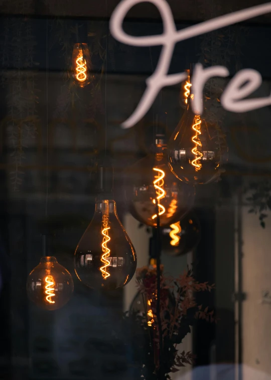 some lit up light bulbs that are hanging from a building