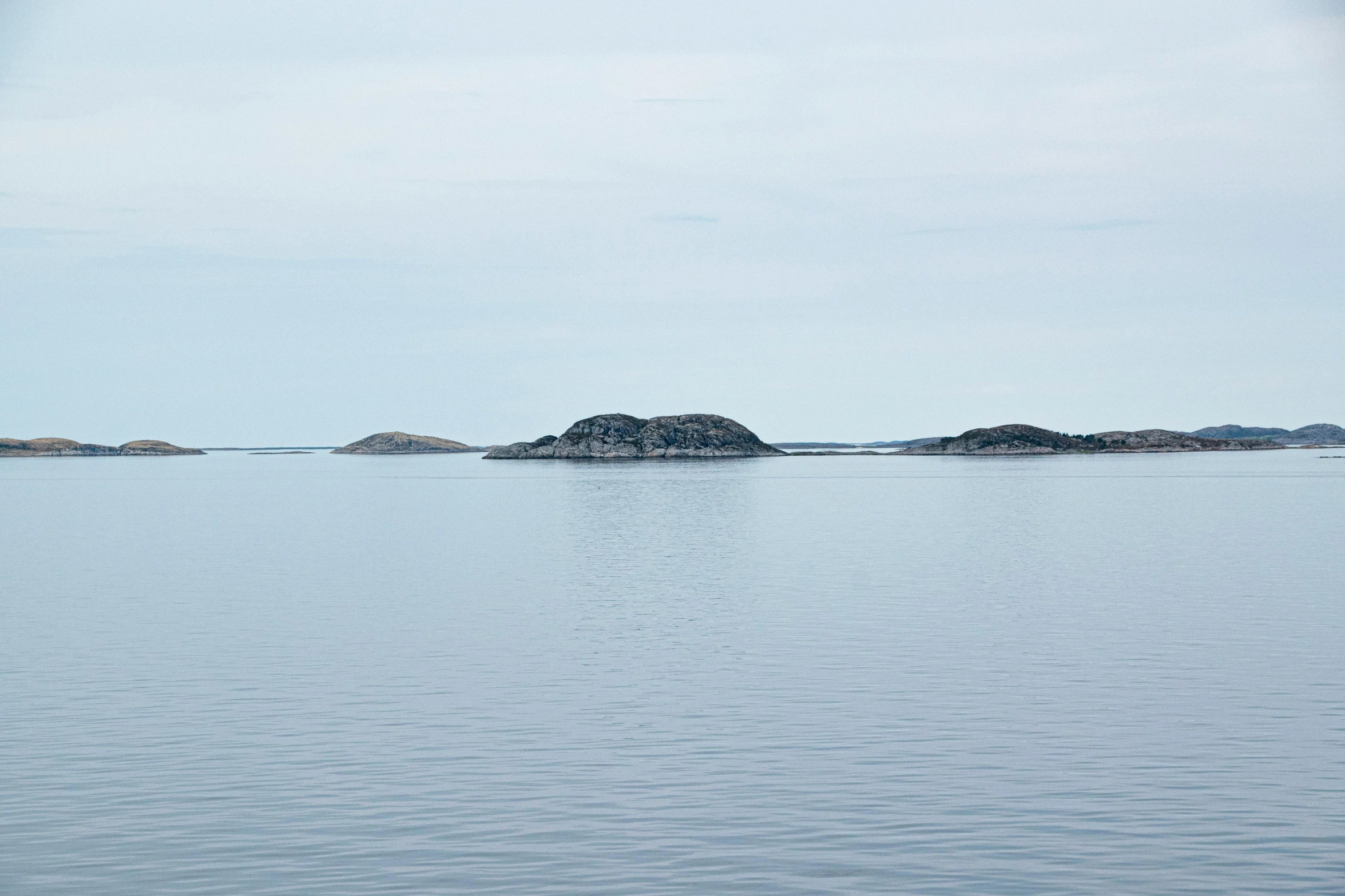 the sea is calm as they move through the distant land