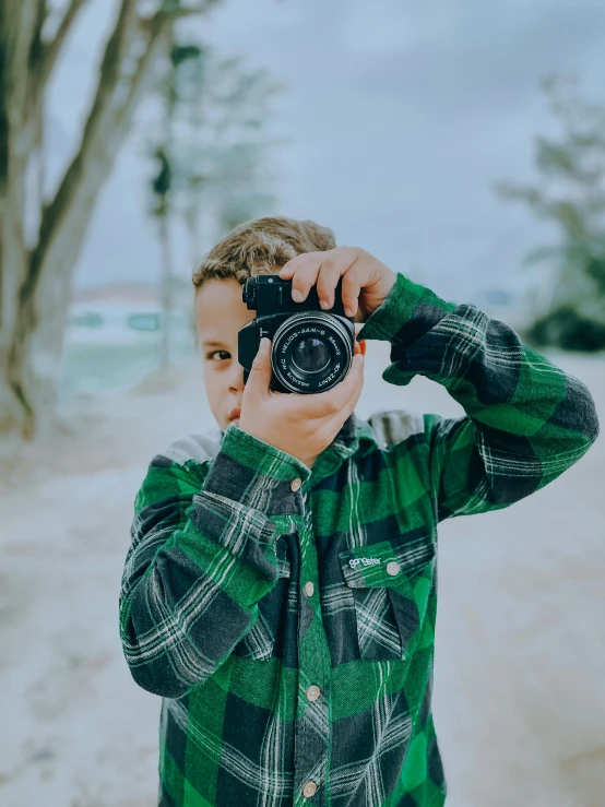 a man in green shirt taking a po with his camera