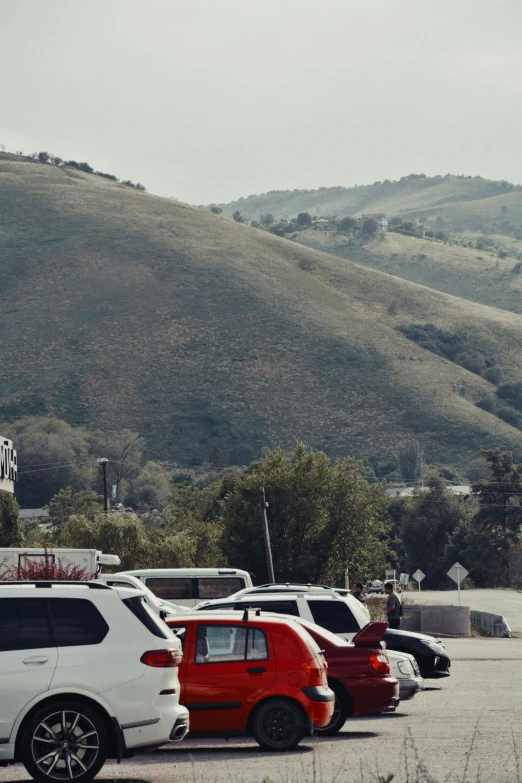 several parked cars in front of a mountain