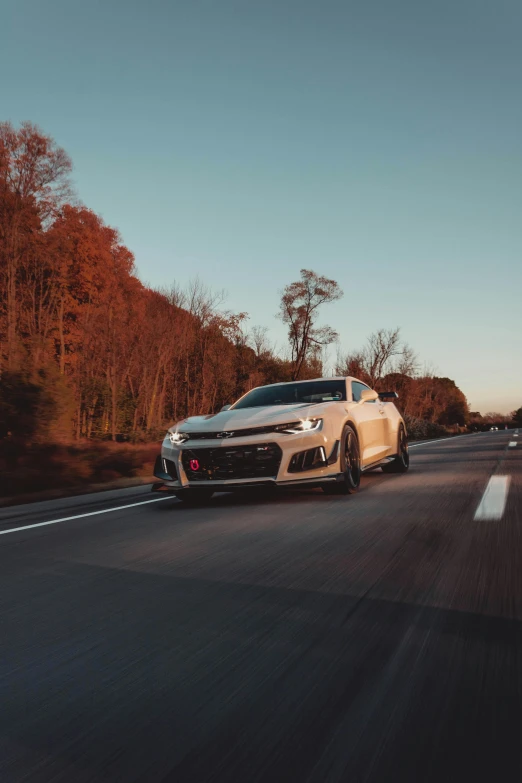 white sports car driving down the middle of a highway