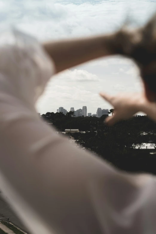 a woman looking out of a window with the city skyline in the background