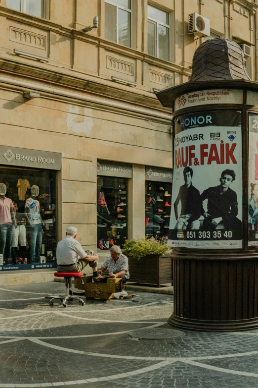 a poster and people on benches outside a building