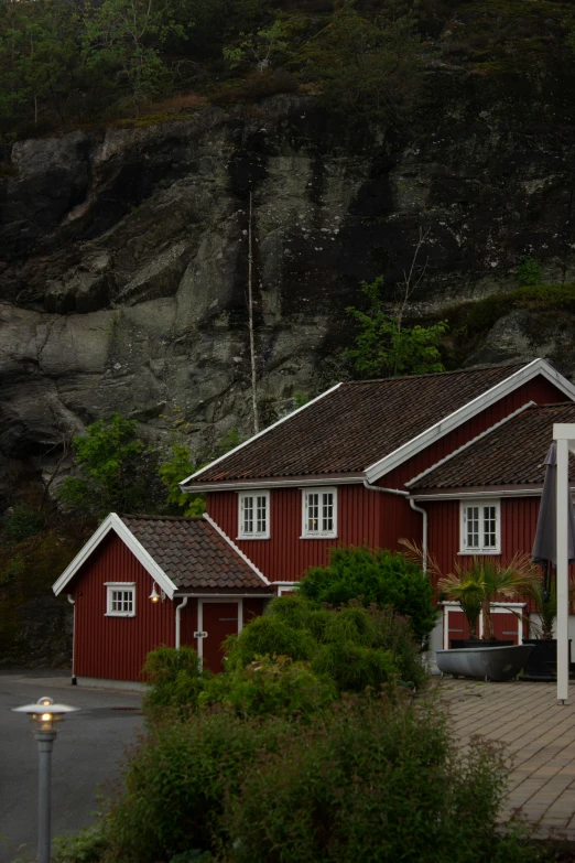 a row of red buildings next to a mountain