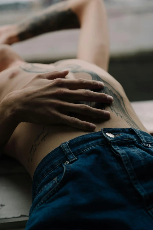 the woman's hand on the shoulder of her tattoo is resting