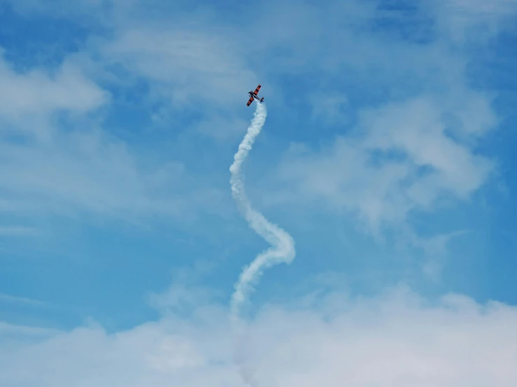 a plane is flying in the air leaving a trail behind it