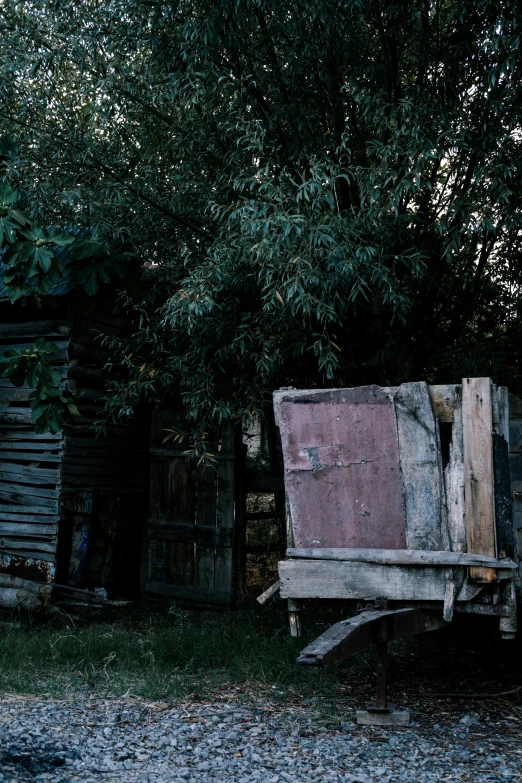 an old wooden bench sitting next to a tree