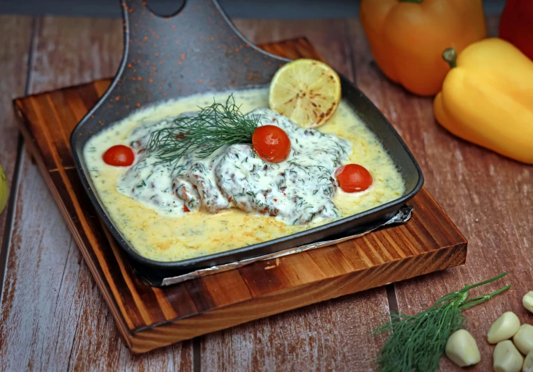 a black dish with food in it sitting on a wooden table