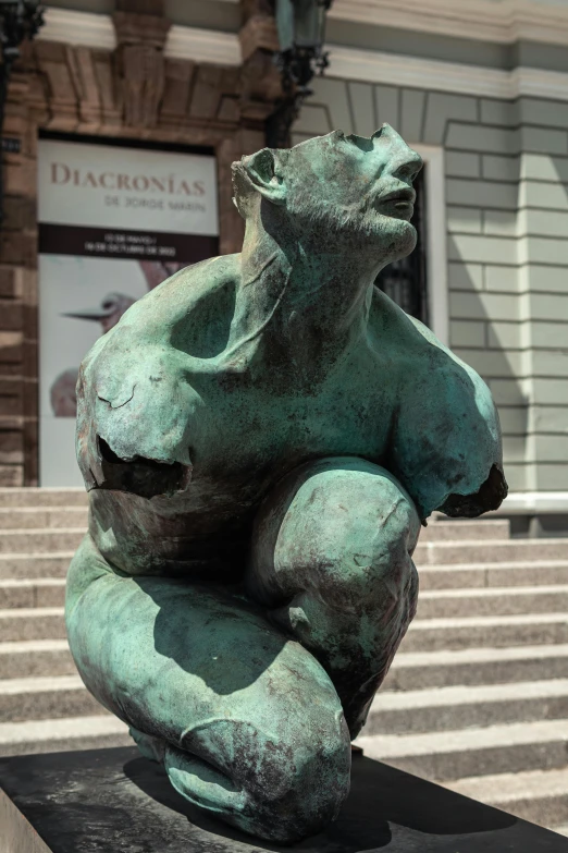 a large green statue sitting on top of a black slab