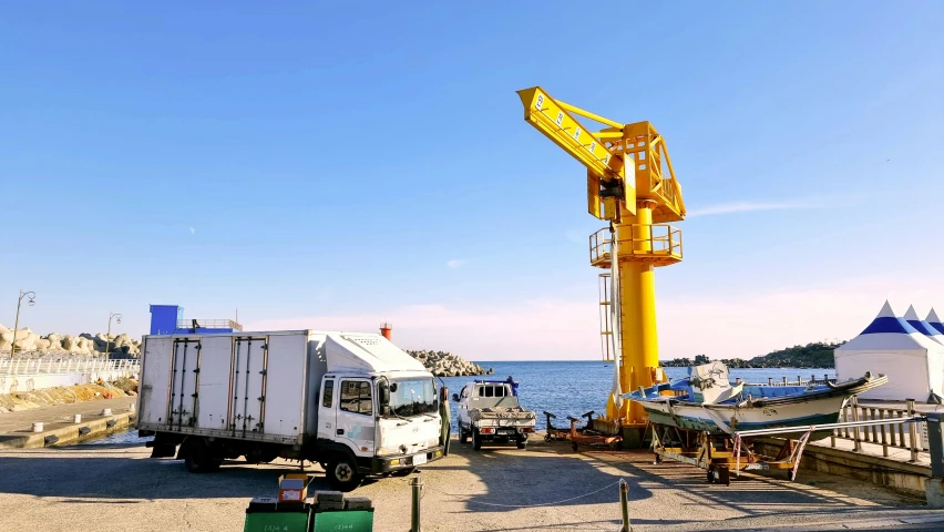 the truck is parked next to the large crane