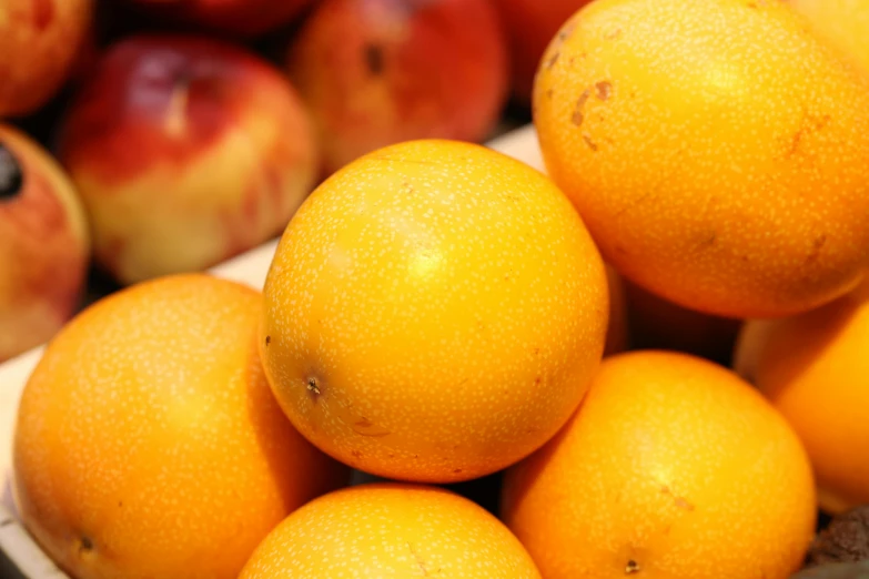 a close up of oranges and apples in the background