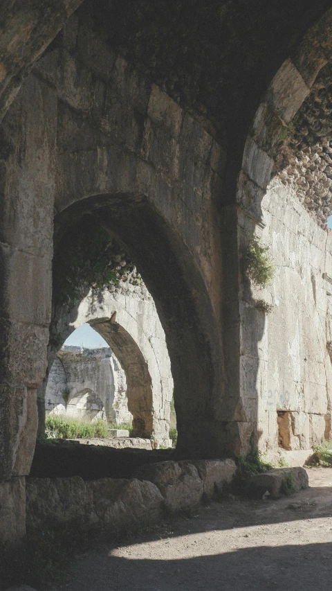 a person standing in an archway next to rocks