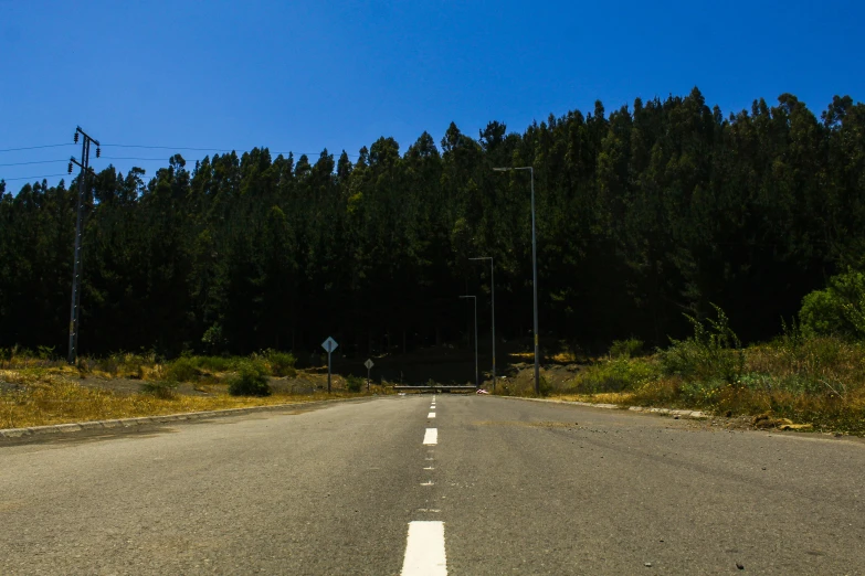 a long empty highway in front of some trees