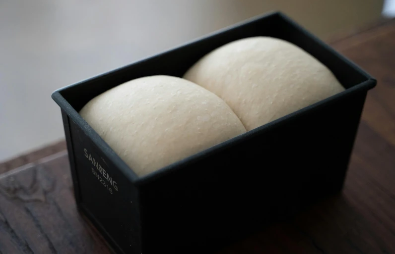 a black box with two round bread in it