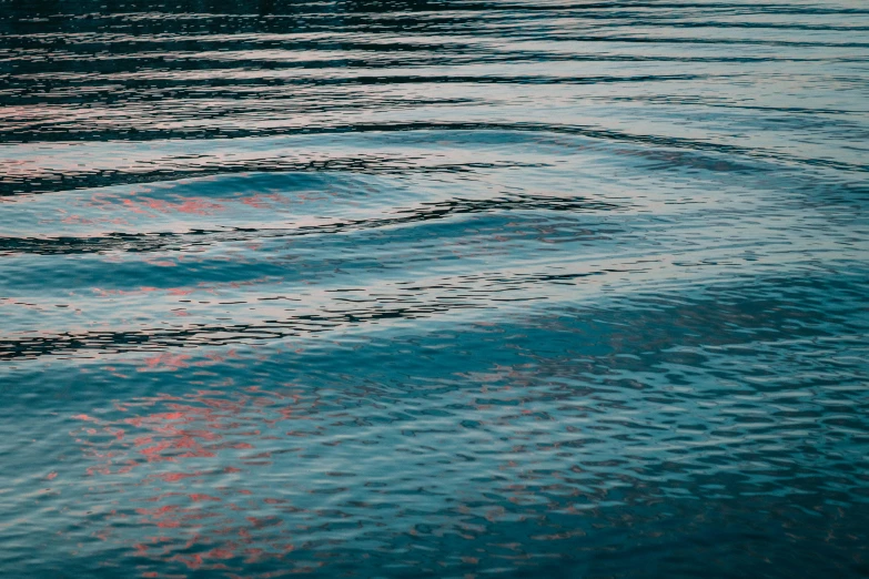 the water has red reflections of clouds in the blue