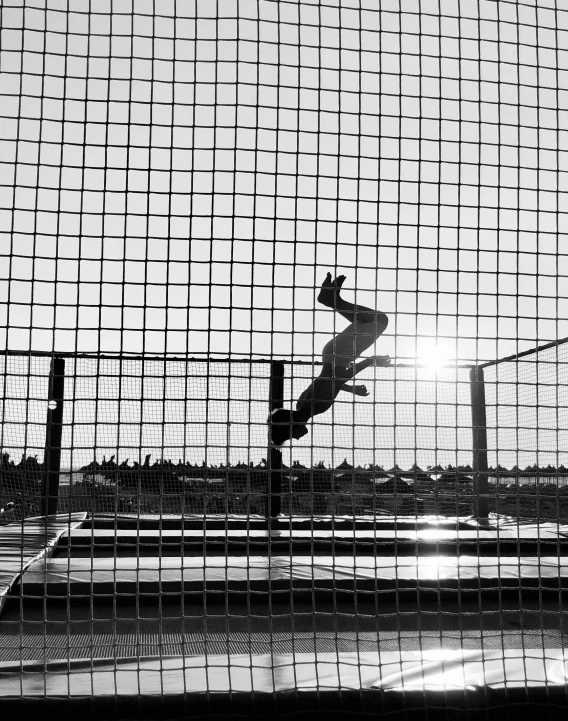 a person on a skateboard is airborne through a fence