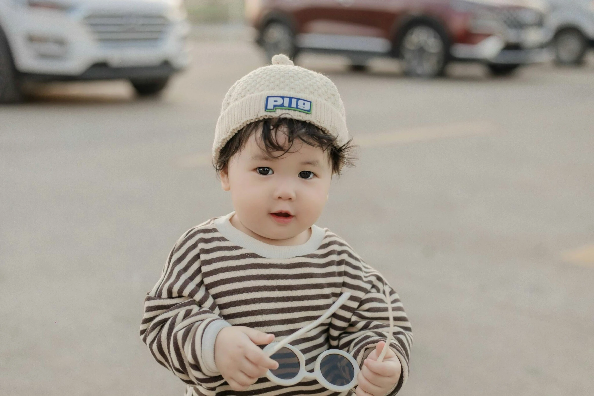 small child riding on a bicycle with a hat on