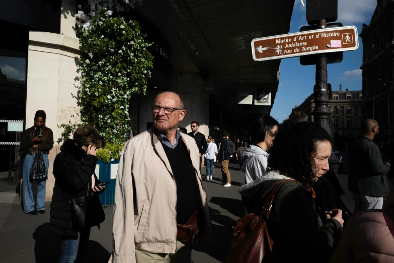 a man walks down a city sidewalk past pedestrians