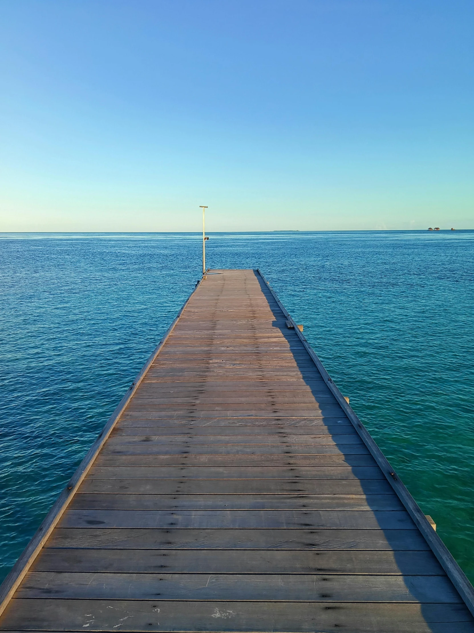 the wooden dock leads into the ocean